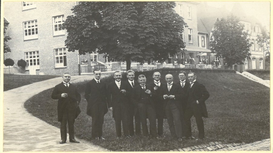 Altes Bild: Gruppe von Männern in Anzügen vor der alten Orthopädie