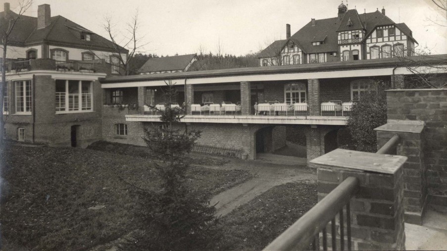 Terrasse mit vielen Betten, die draußen stehen. Die damaligen Liegebalkone der Klinik.